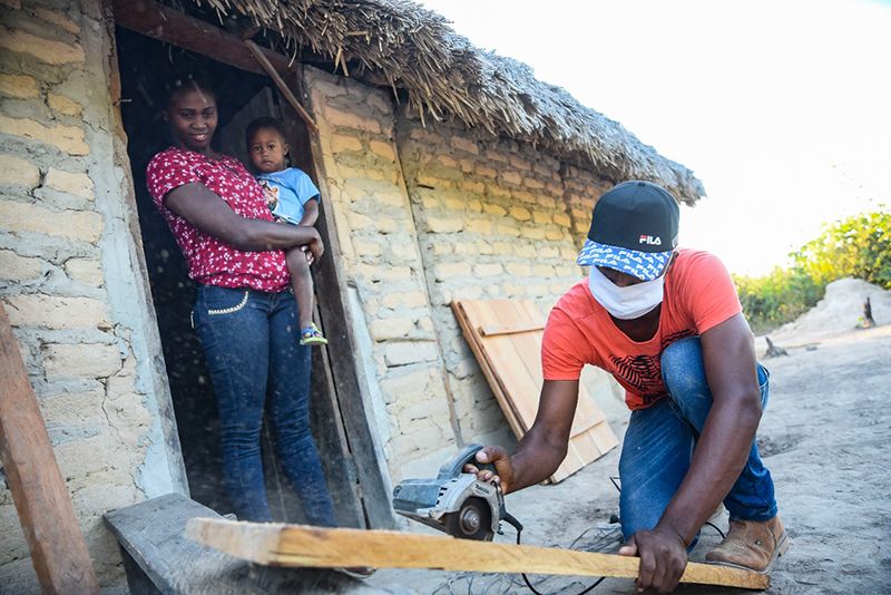 Moradora com o filho no braço é beneficiada com a chegada de energia elétrica em Cavalcante: mais ação