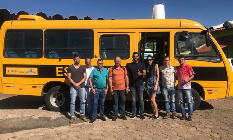 Prefeito SÃ¡vio com servidores da Prefeitura de Pilar de GoiÃ¡s ao lado do novo Ã´nibus para estudantes